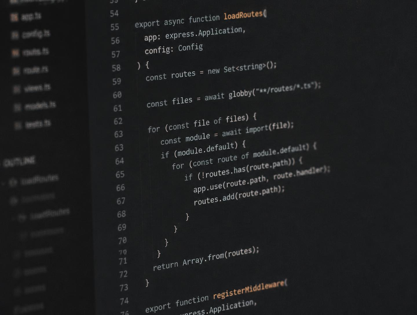 Close-up of application source code displayed on a dark editor screen with a file tree in the sidebar